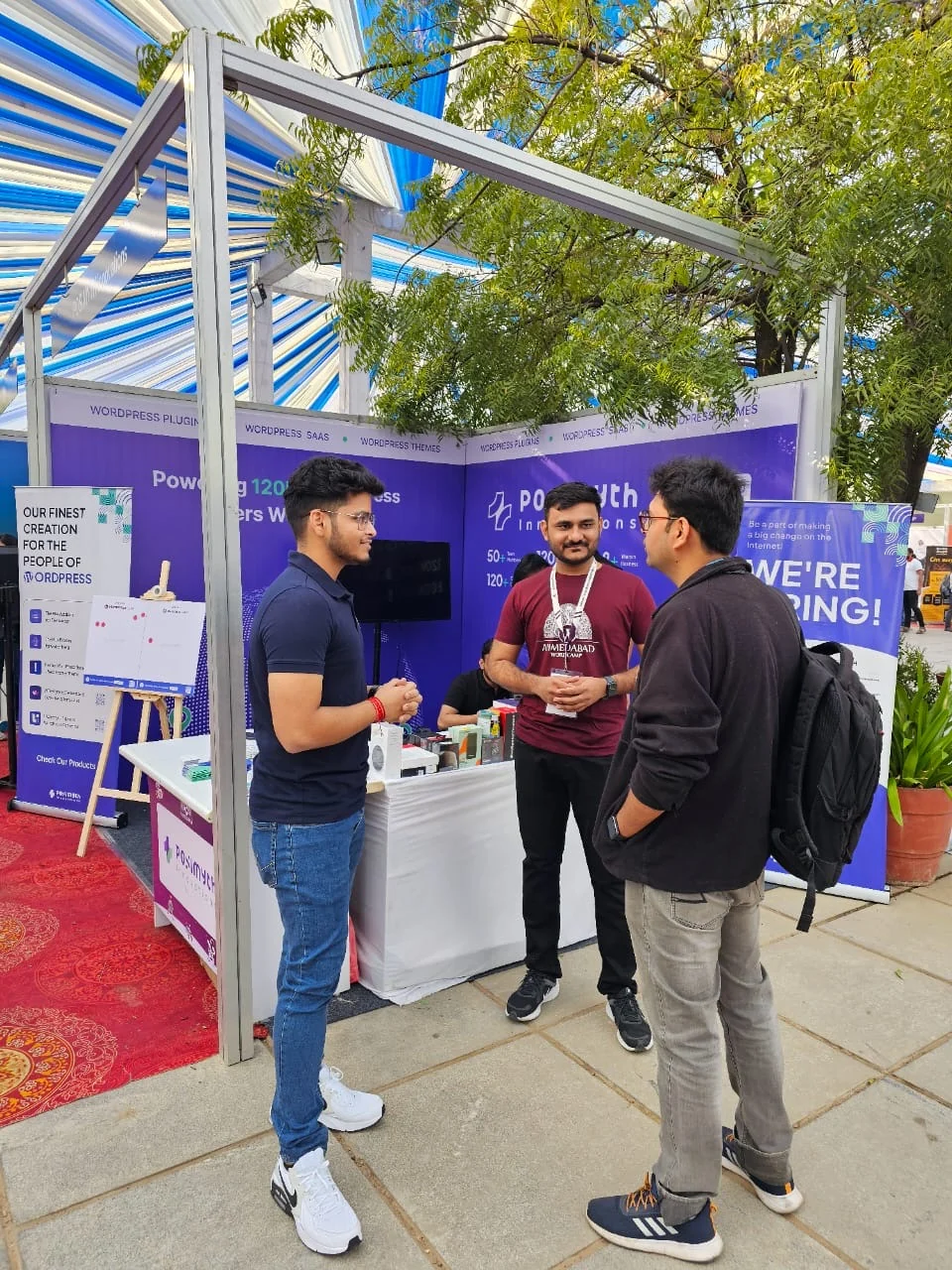 Visitors talking to the team at the POSIMYTH booth